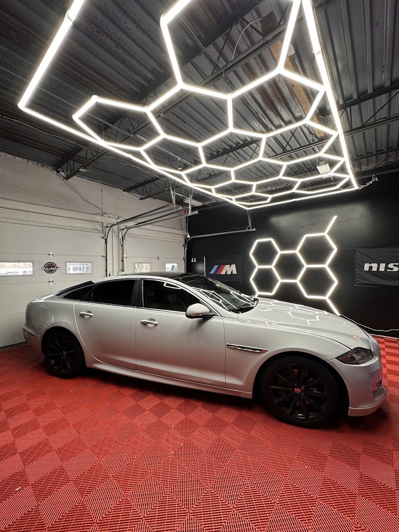 Silver Jaguar XJ inside Auto Addict shop with hex LED lights